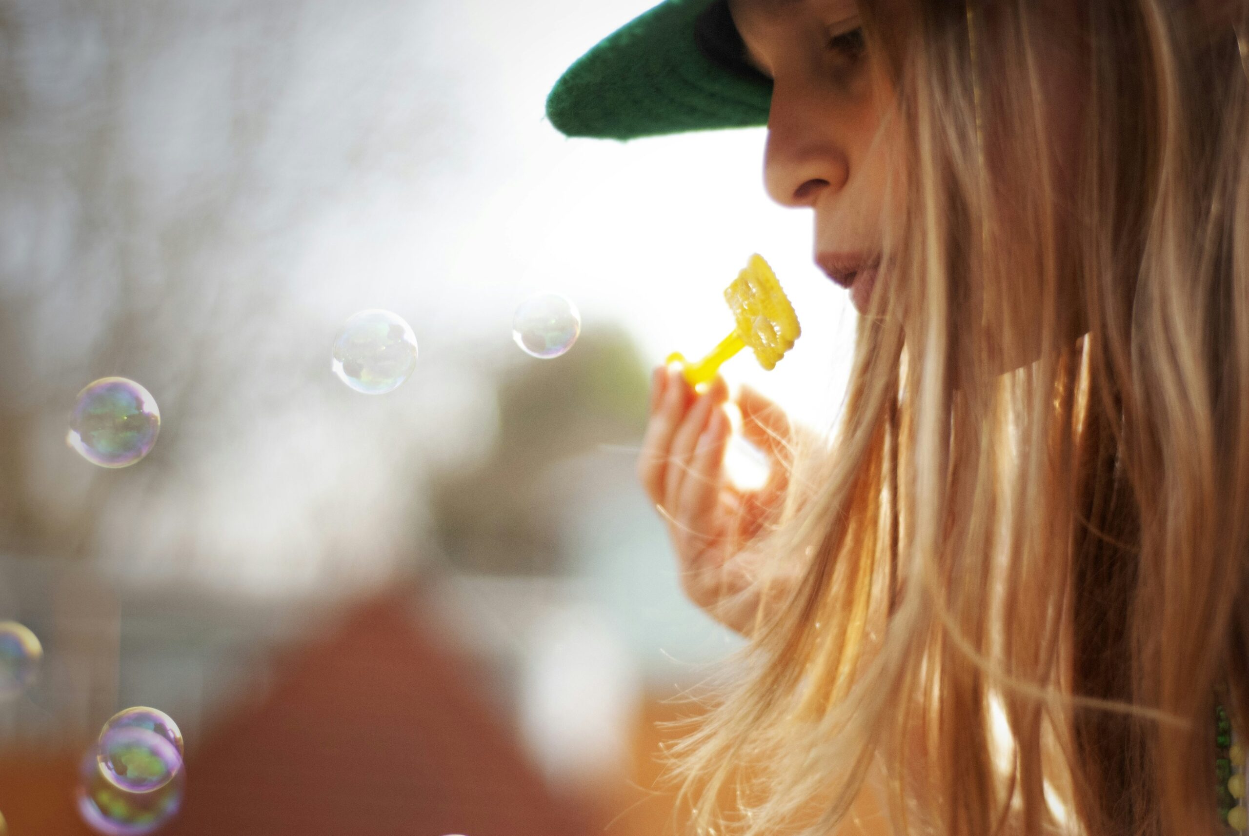 A happy golden retriever chewing on a sparkling clean glass toy outdoors.