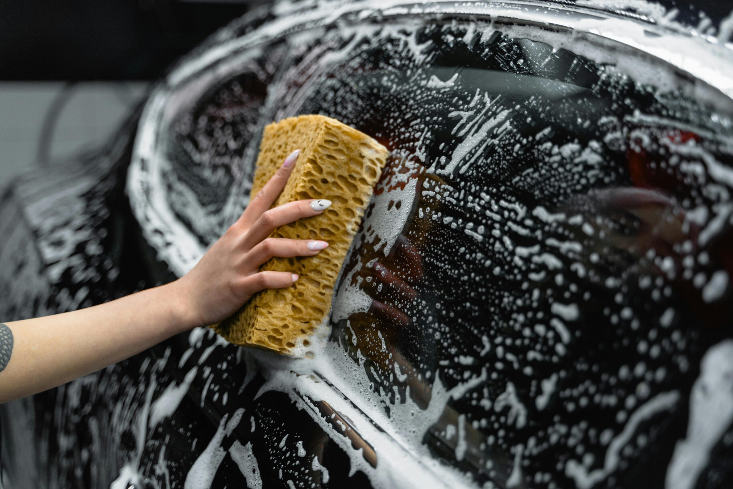 A person cleaning glass toys with soapy water