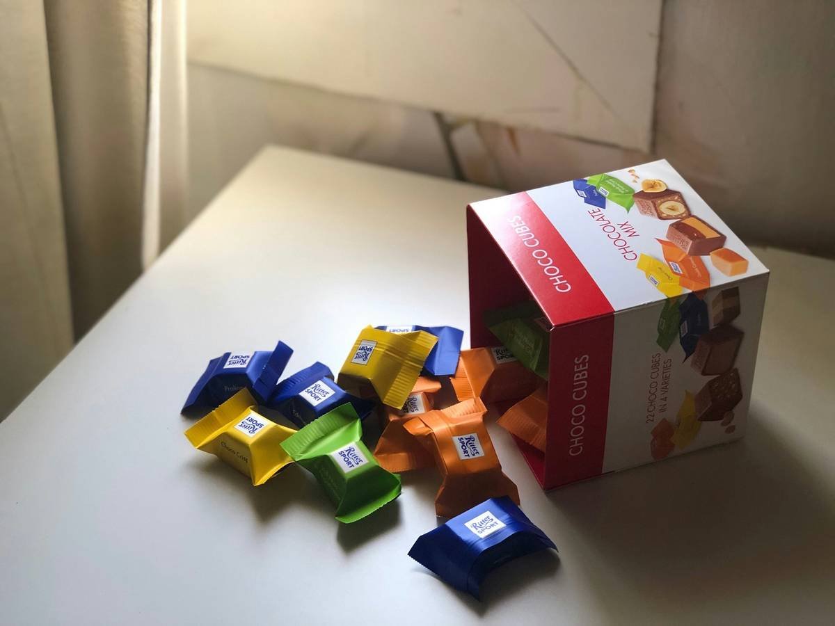 A cat playing with a durable glass toy indoors.