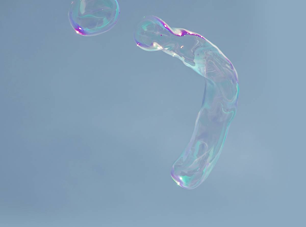 Two dogs playing with colorful glass toys in a living room.
