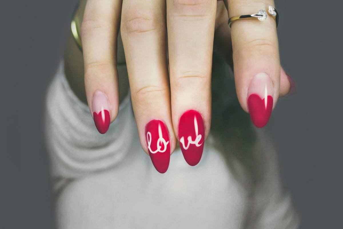 a woman's hand with a red and white manicure