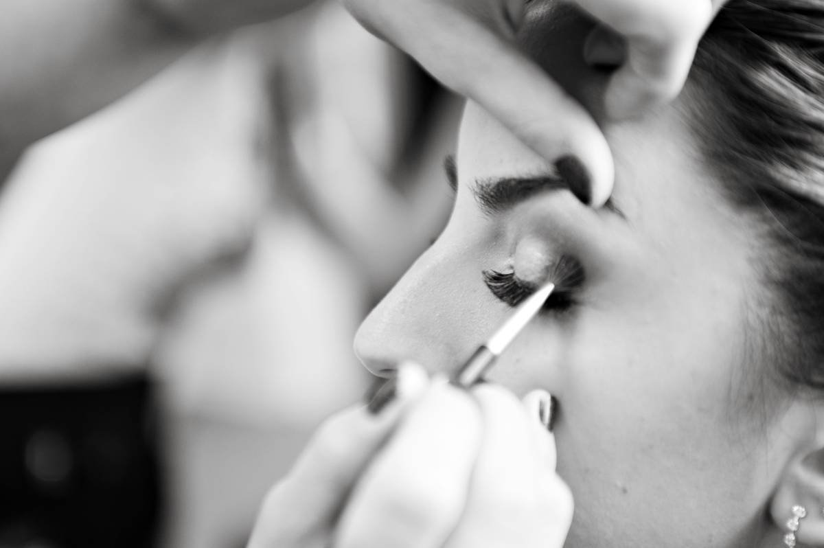 makeup artist applying eye shadow in black and white